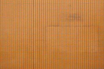 Textured wall with an orange grid pattern highlighting its structured design elements