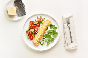 Delicious french omelette with cheese served with fresh vegetables