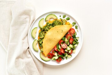 Omelet with roasted broccoli and cheese served with salad from fresh vegetables