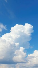 Obraz premium Big puffy white clouds drifting lazily across the blue sky, cloudy, serene, clouds