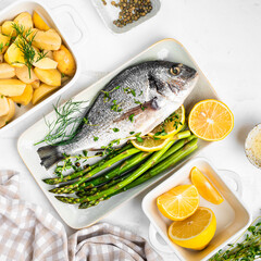 he concept of a delicious dinner. raw dorado fish with asparagus, lemon and potatoes