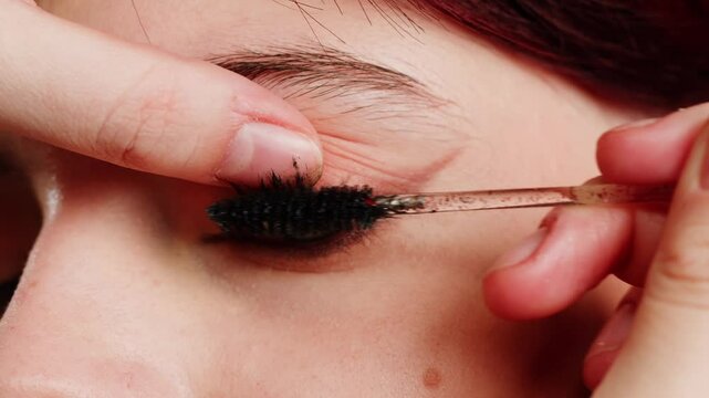 Eye shadow makeup to the upper eyeliner, close-up. Makeup artist applies a bright eye shadow with a makeup brush.Tutorial master class of professional makeup. 
