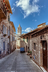 Winding streets reveal stunning medieval houses in Assisi, Umbria, where stone facades and charming balconies exude timeless beauty and history.