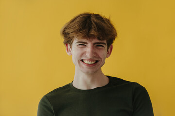 Young Smiling Man Posing Against Vibrant Yellow Background