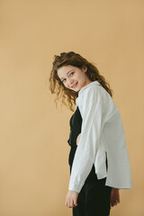 Young Woman in Stylish Casual Outfit Smiling Against Beige Background