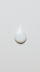 Fototapeta premium A pristine droplet of white liquid rests on a neutral surface, its smooth texture reflecting light. The composition is minimalist and clean.