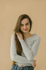 Obraz premium Portrait of Woman in Casual Grey Shirt Against Beige Background