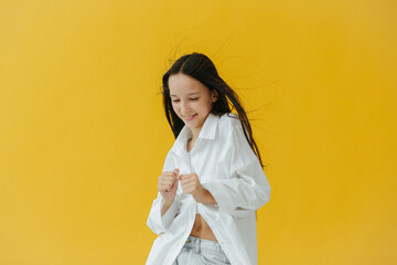 Portrait of a Smiling Girl in a White Shirt With Yellow Background