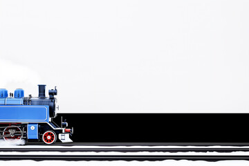 A classic blue steam locomotive captured in motion on a track, featuring a vintage design with red wheels and black detailing, set against a contrasting dark background. Copy Space 