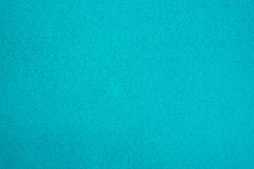 The photo is turquoise in color with small dark patches.The texture of felt fabric for sewing.