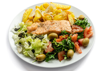 Baked red fish with fresh vegetables and baked potatoes on a white background. Healthy food.