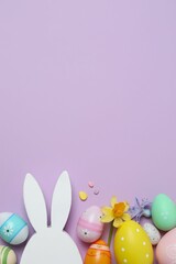 Happy Easter. Colorful eggs, bunny ears and yellow flowers on color background, space for text or advertising