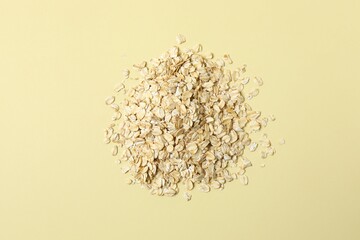 Composition with oatmeal flakes on beige back ground. Cooking breakfast