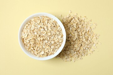 Composition with oatteal flakes on beige back ground. Cooking breakfast