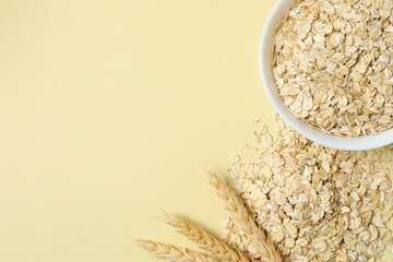 Composition with oatteal flakes on beige back ground. Cooking breakfast