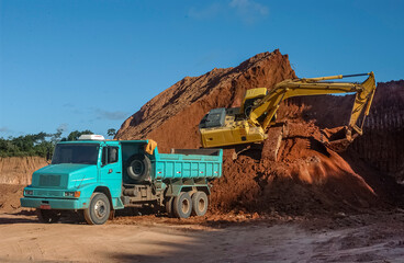Excavator and dump truck at construction site in João Pessoa,  Paraíba, Brazil on August 11, 2003.