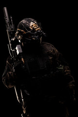 Special forces soldier geared with night vision and tactical equipment on black background