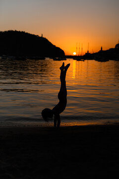 Silhouette of a child doing a handstand at sunset in Soller, Majorca