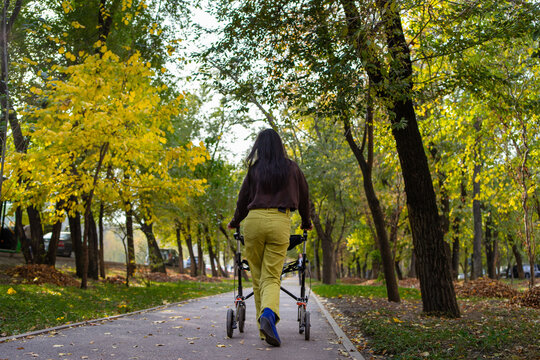 Woman with Cerebral Palsy Walking with Walker in the Park