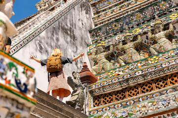 Exploring wat arun in Bangkok, female tourist admiring temple architecture