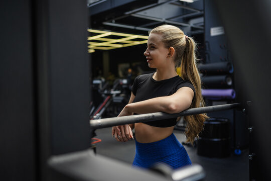 Fit blonde woman taking a break in modern gym environment
