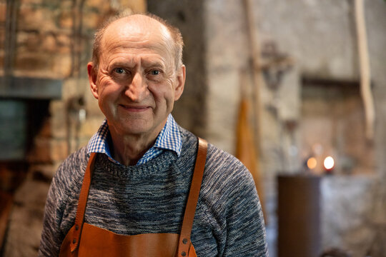 Experienced Blacksmith Smiling in Traditional Workshop