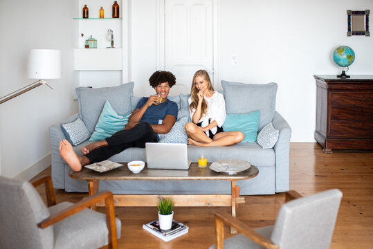 Relaxing at home: couple enjoying drinks and laptop time