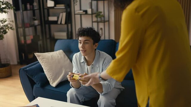 Mother reprimanding her teen son for excessive gaming, struggling with addiction