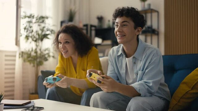 Teen and his mom celebrating a video game victory, giving each other a high five