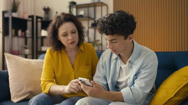 Teen son helping his mother set up a phone app, resolving internet access issues