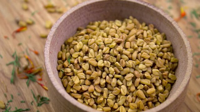 Close-up. Fenugreek seeds in wooden bowl &ndash; traditional spice for seasoning