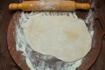 Hands of a Jewish woman roll out dough for gomentashi ears of Haman