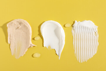 Samples of different cosmetic products on yellow background, flat lay