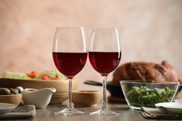 Red wine and delicious dinner served on wooden table