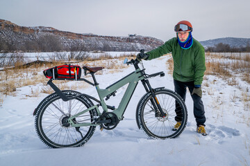 senior male cyclist with a touring electric bike in Colorado foothills in winter scenery