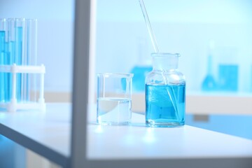 Laboratory glassware with liquid on shelf indoors