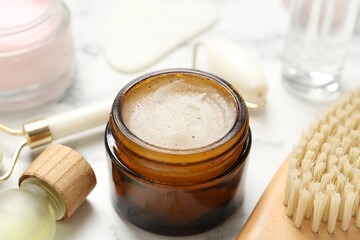 Different body care products on white marble table, closeup