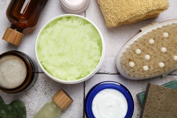 Different body care products on light tiled table, flat lay