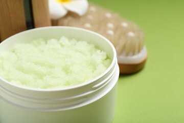 Body care product in jar on green background, closeup. Space for text