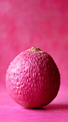 Pink Lychee: A vibrant close-up showcases a single, pink lychee fruit, its textured skin contrasting beautifully against a monochromatic background.