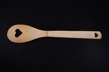 Bamboo Cooking Spoon with Heart Cutout on a Black Background