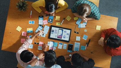 Top view of software developer team looking Ux Ui design for mobile phone interface from tablet...