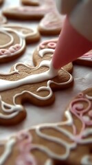 Sweet Creations: Close-up view of the delicate art of decorating gingerbread cookies with pink icing, creating festive treats