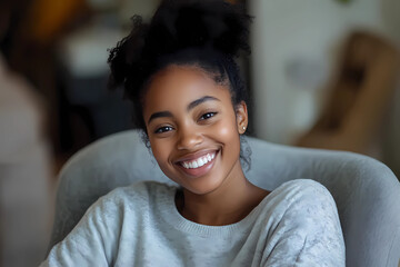 happy young african american young woman sitting in her chair smiling. 