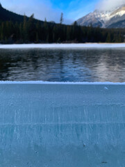 Thick Ice Layer with Frozen Bubbles and Mountain Lake View