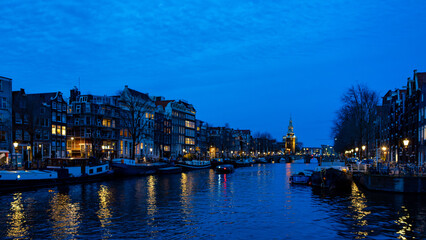 View of Amsterdam from a boat on the Amstel canal at blue hour