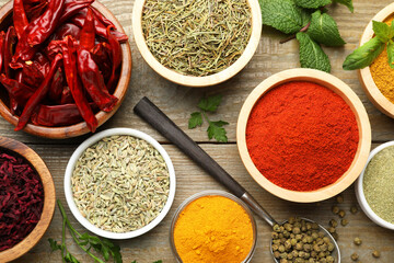 Different aromatic spices on wooden table, flat lay