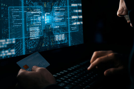 Criminal anonymous male approaching credit card of personal information database for codding encryption scam program in privacy system at night time at blue neon light room with server drive. Surmise.
