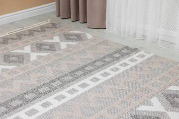 Stylish soft rug with pattern on floor indoors