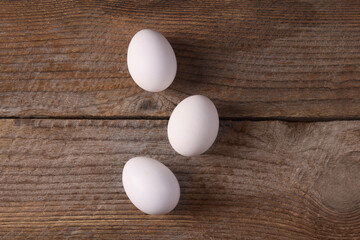 Group of fresh eggs on wooden table, flat lay
